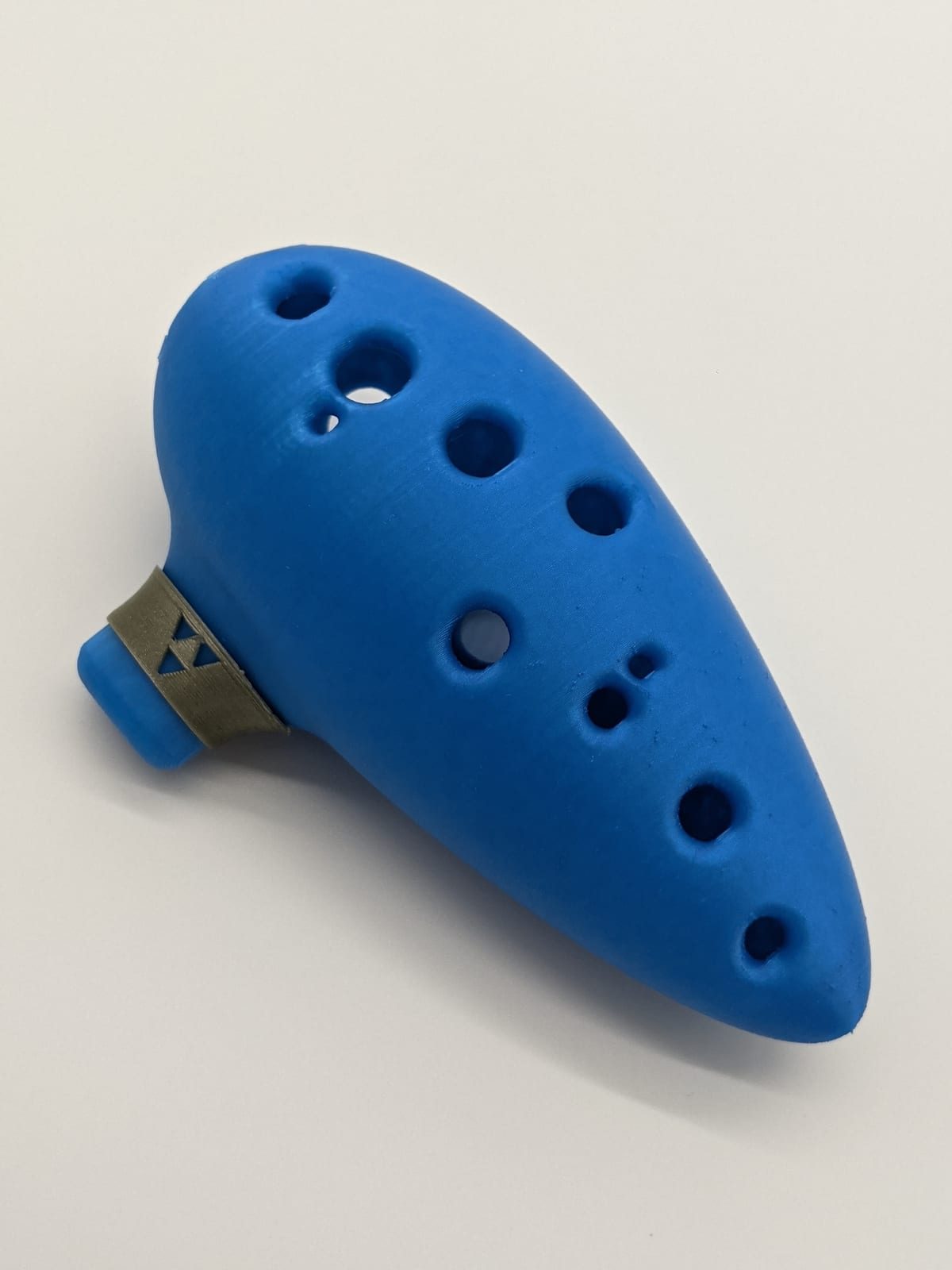 Blue 3D-printed 12-hole ocarina with a brass mouthpiece