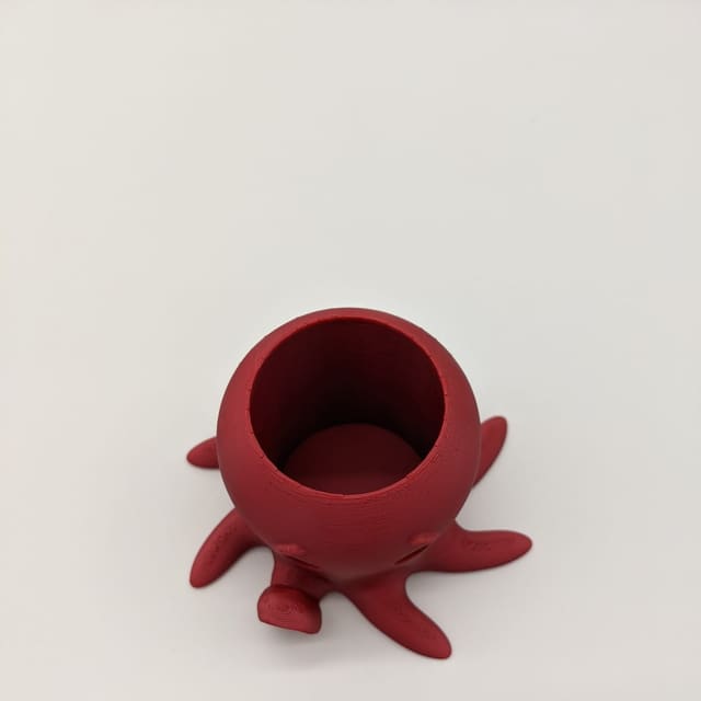 Small red 3D-printed octopus cup that sits on its tentacles
