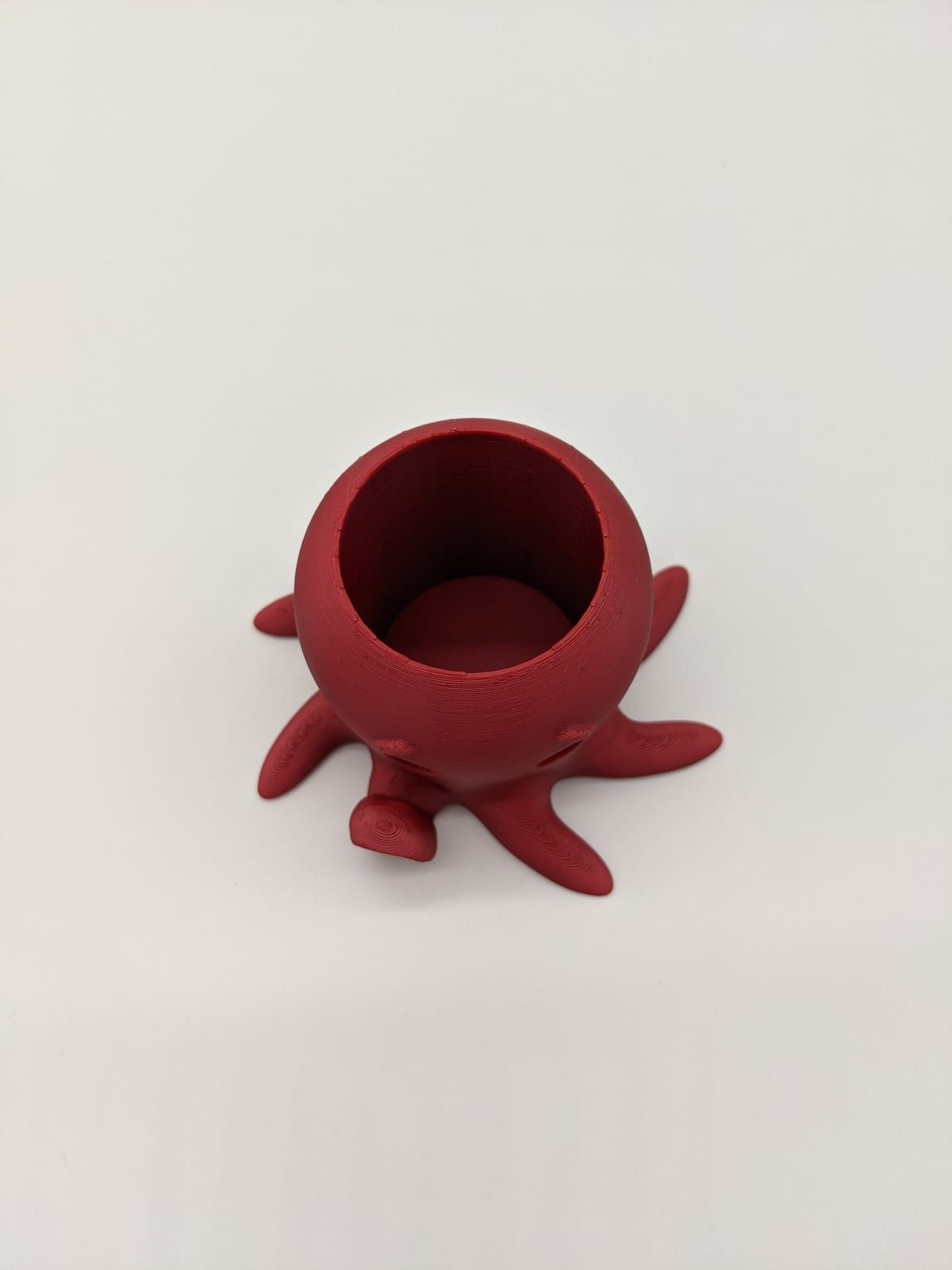 Small red 3D-printed octopus cup that sits on its tentacles