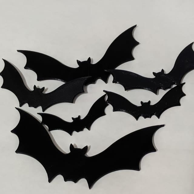 A set of flat black 3D-printed bat silhouettes in several sizes