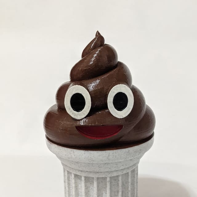 A smiling brown 3D-printed poop emoji displayed on a white classical pedestal